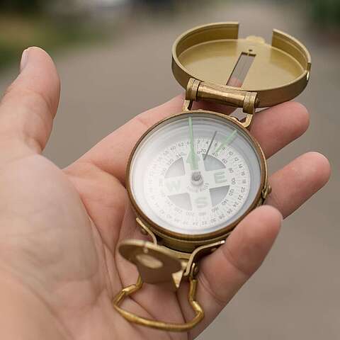 eine Hand hält einen Kompass