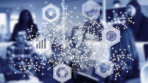 Digitalisierung fördert die Wettbewerbsfähigkeit Eine digitale Illustration eines Globus, bestehend aus miteinander verbundenen Knoten und Linien. Um den Globus herum befinden sich Sechsecke mit Symbolen, die verschiedene Technologien darstellen, wie beispielsweise Diagramme und ein Bitcoin-Symbol. Menschen sind im Hintergrund unscharf dargestellt.